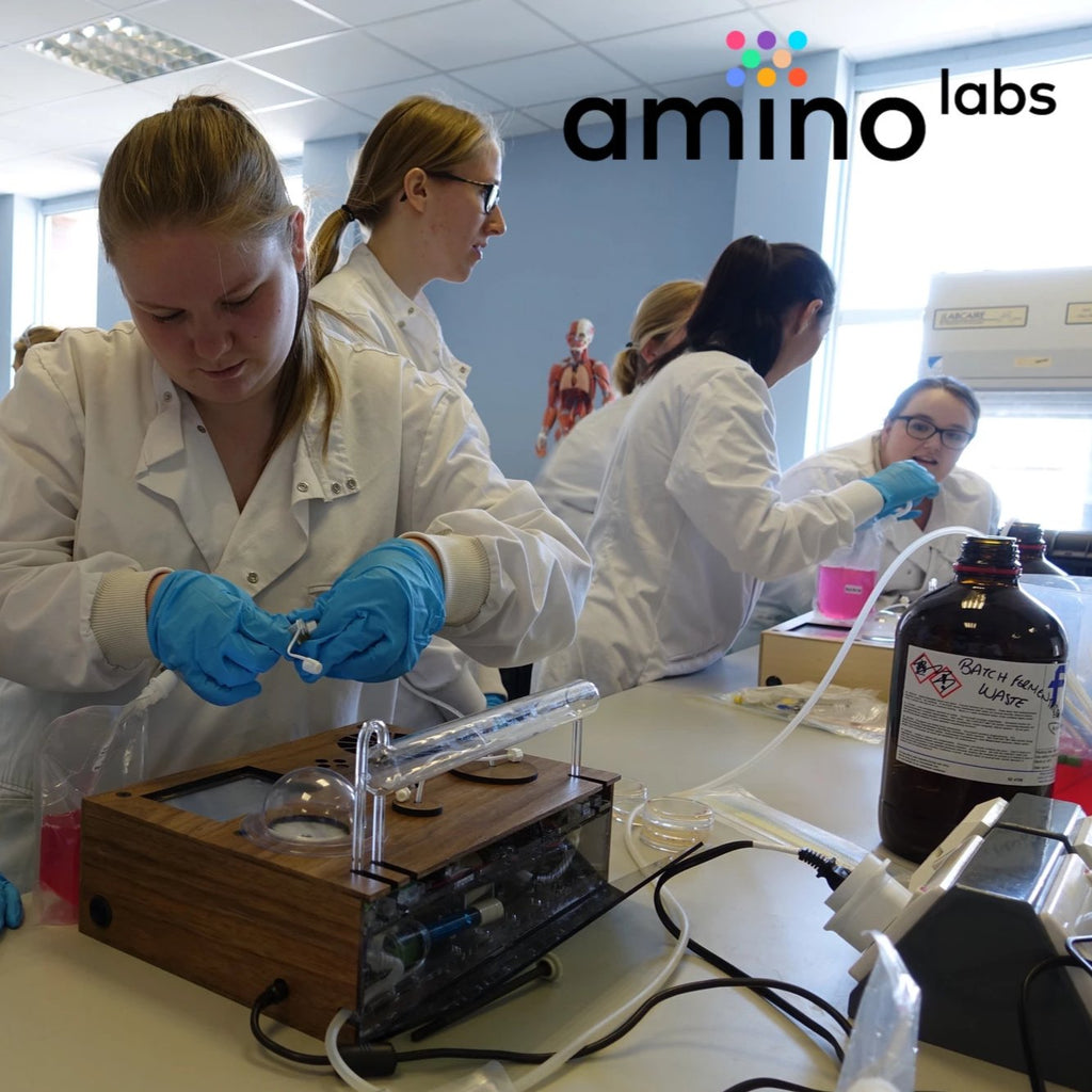 DIY biologists in lab coats in college biotechnology elective during a Genetic Engineering DIY biohacking workshop by Amino labs STEM biotechnology kits and school laboratory equipment / home laboratory equipment / biohacking laboratory equipment